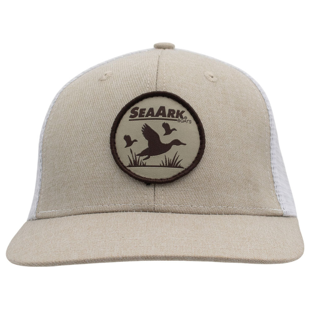 A beige trucker-style cap with a circular patch on the front featuring duck silhouettes and the sea ark logo.