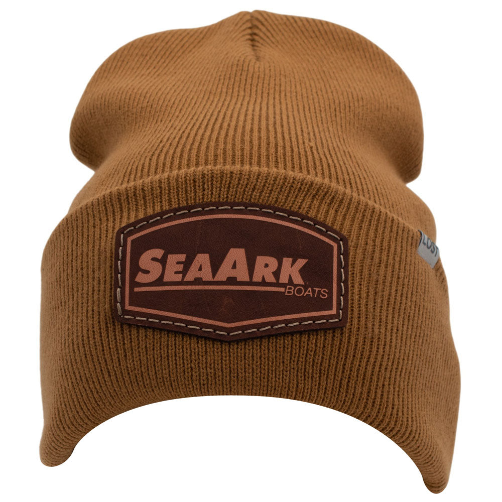 Front of a caramel brown ribbed knit beanie hat featuring a brown leather patch on the front with the text 'SEAARK BOATS' in tan lettering, shown against a plain white background.