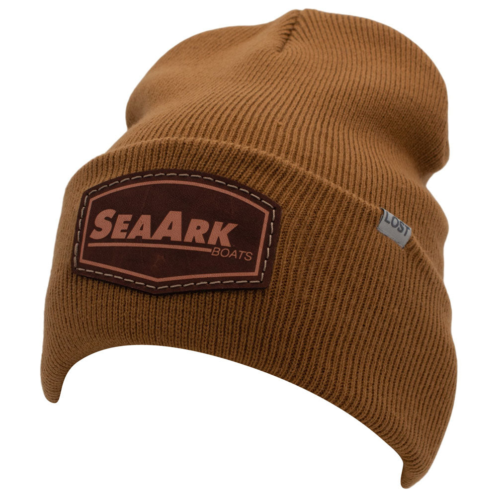 A caramel brown ribbed knit beanie hat featuring a brown faux-leather patch on the front with the text 'SEAARK BOATS' and a small gray 'LOST' tag on the side, set against a plain white background.