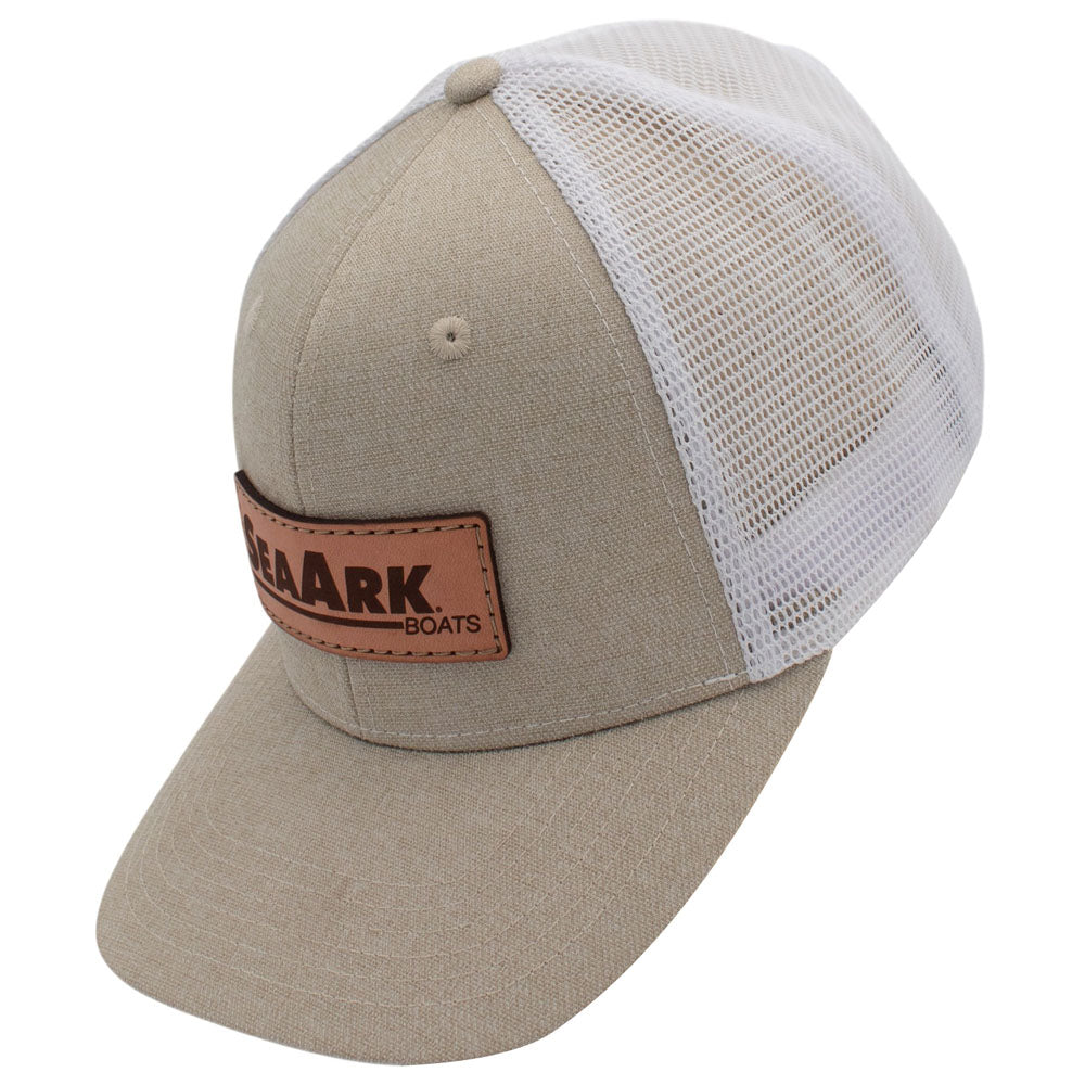 Side of a beige and white trucker hat with a brown leather patch on the front.