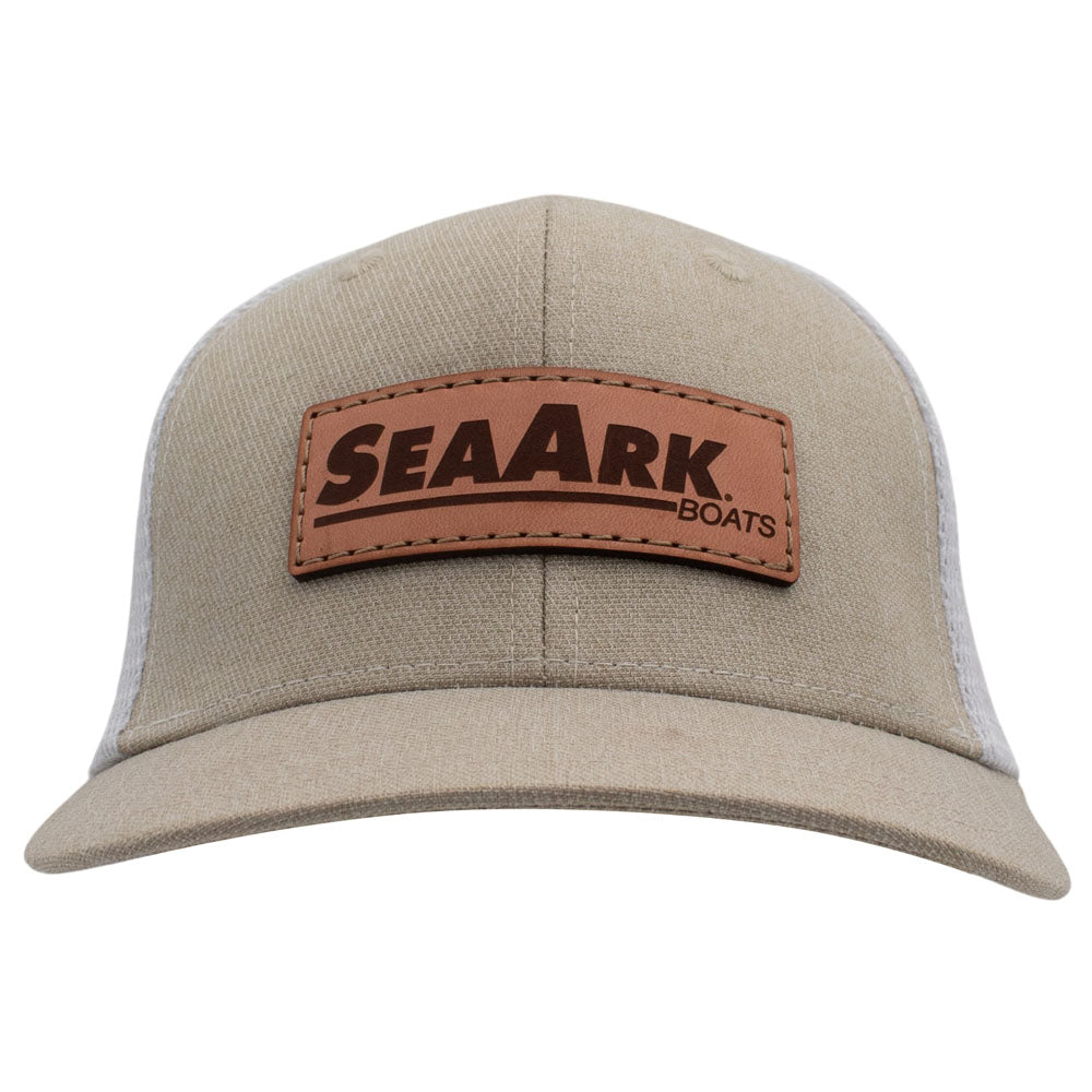 A beige trucker-style cap with a brown leather patch on the front that reads 'SEAARK BOATS' in dark brown lettering/