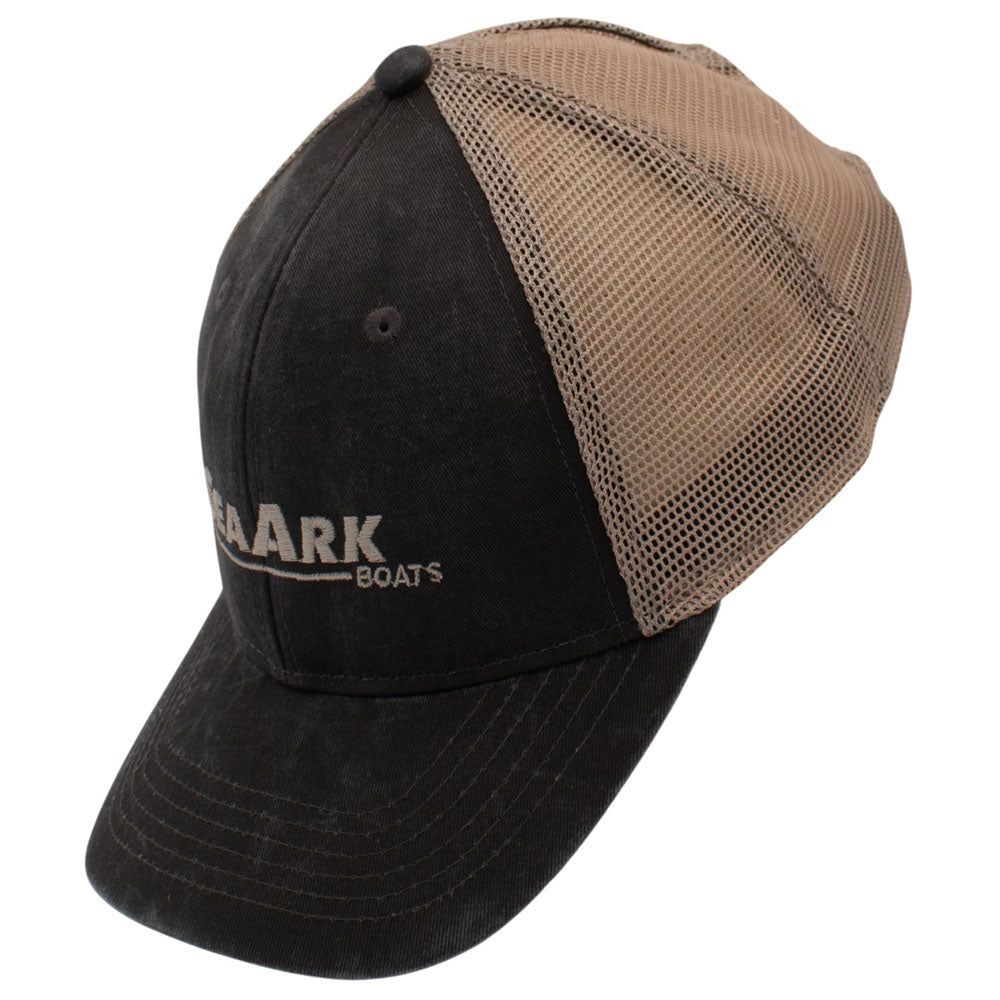 Side of a trucker-style baseball cap with a dark grey front panel and brim, tan mesh back panels, and a small embroidered logo on the front.